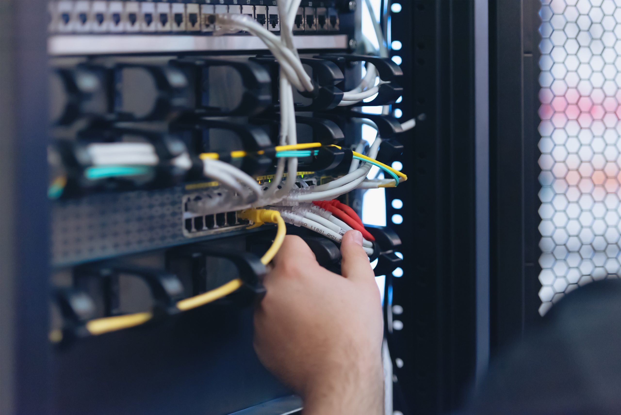 An Expert Engeneer in datacenter server room  connecting cables in server cabinet in network server room.